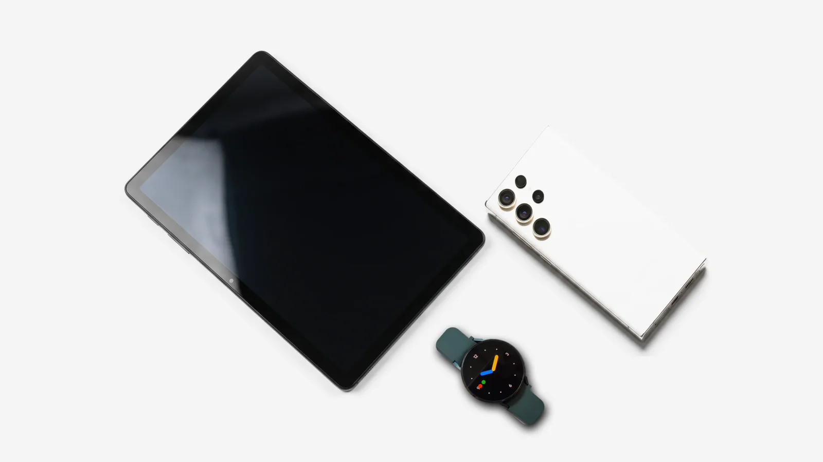 Samsung Galaxy Tab, Galaxy Watch4 mit grünem Armband und weißes Galaxy S Ultra von oben auf hellem Hintergrund